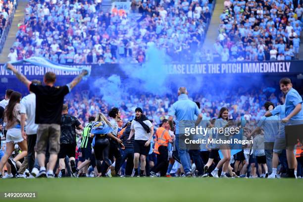 General view as fans of Manchester City invade the pitch, as the LED Perimeter Board displays the message "Please Leave The Pitch Immediately", after...