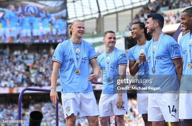 Erling Haaland of Manchester City looks on as players of Manchester City collect their Winners Medals and wait on the stage during the Trophy...