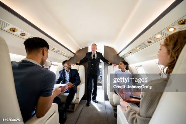private jet pilot visiting with passengers - customer experience stock pictures, royalty-free photos & images
