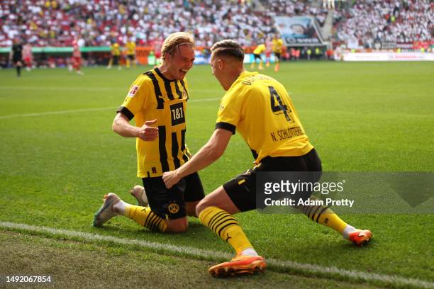 Julian Brandt of Borussia Dortmund celebrates with teammate Nico Schlotterbeck after scoring the team's third goal during the Bundesliga match...