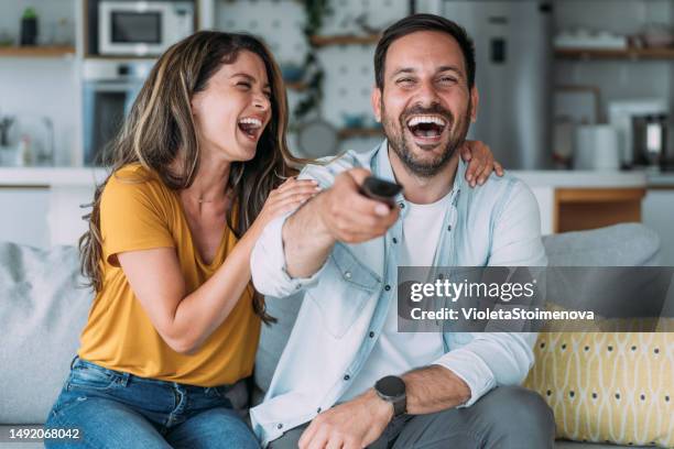 cute young couple cuddling while watching tv. - couple tv bildbanksfoton och bilder