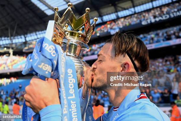 Jack Grealish of Manchester City kisses the Premier League Trophy following the Premier League match between Manchester City and Chelsea FC at Etihad...