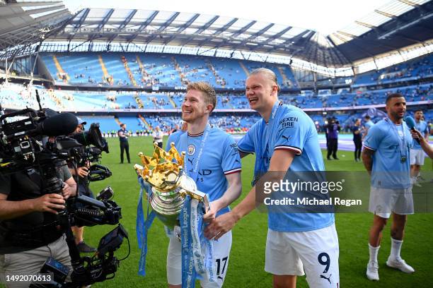 Kevin De Bruyne of Manchester City celebrates with the Premier League trophy following and with teammate Erling Haaland following the Premier League...
