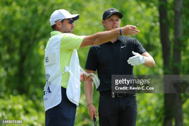 Cameron Davis of Australia talks with caddie Andrew Tschudin on the fourth tee during the final round of the 2023 PGA Championship at Oak Hill...