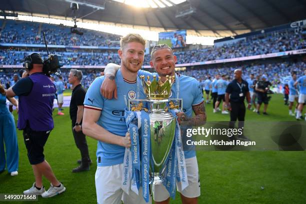 Kevin De Bruyne of Manchester City poses for a photograph with the Premier League Trophy and Kalvin Phillips following the Premier League match...