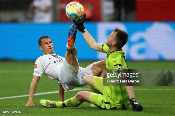 Lukas Hradecky of Bayer 04 Leverkusen makes a save from Stefan Lainer of Borussia Moenchengladbach during the Bundesliga match between Bayer 04...