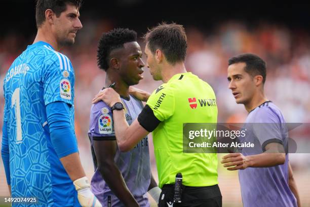 Referee Ricardo de Burgos Bengoetxea speaks with Vinicius Junior of Real Madrid after receiving Racist abuse from the crowd during the LaLiga...