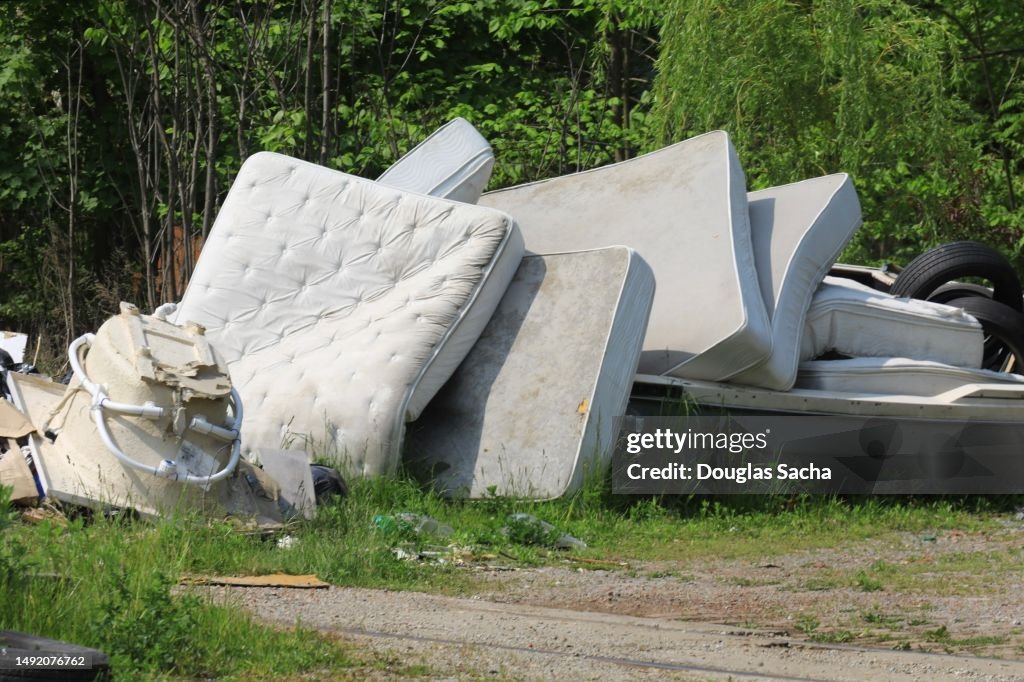 Illegal dumping field with trash and old mattresses