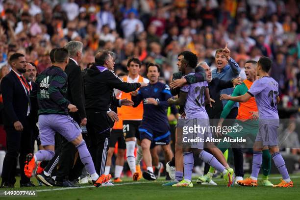 Players and staff escort Vinicius Junior of Real Madrid off of the pitch after he is shown a red card during the LaLiga Santander match between...