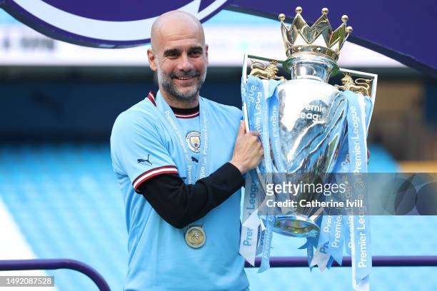 Pep Guardiola, Manager of Manchester City, poses for a photograph with the Premier League Trophy following the Premier League match between...