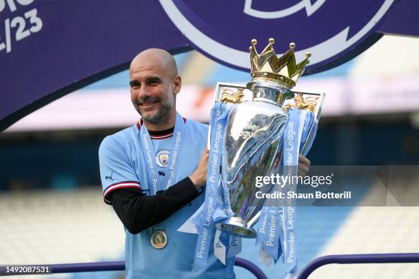 Pep Guardiola, Manager of Manchester City, poses for a photograph with the Premier League Trophy following the Premier League match between...