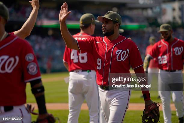 Jeimer Candelario of the Washington Nationals high fives teammates after winning against the Detroit Tigers at Nationals Park on May 21, 2023 in...