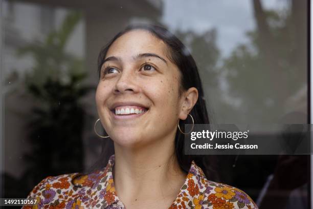 smiling long haired woman looking through window - staring stock pictures, royalty-free photos & images