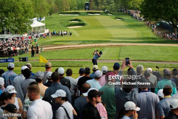 Corey Conners of Canada plays his shot from the 14th tee as fans look on during the final round of the 2023 PGA Championship at Oak Hill Country Club...
