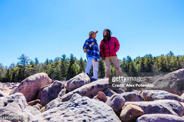 couple exploring rock area. romantic couple of latino man with locks and woman in hat hiking in rock area among sandstones in hickory run boulder field, poconos, pa - pennsylvania nature stock pictures, royalty-free photos & images