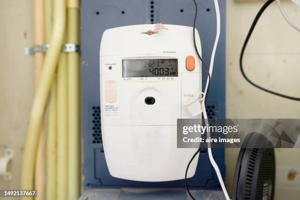 close-up of a white electric meter on a wall of a house with numbers, front view. - the home front stockfoto's en -beelden