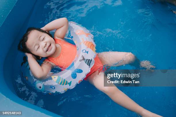 asian chinese baby girl enjoying me time in inflatable swimming pool - me time stock pictures, royalty-free photos & images