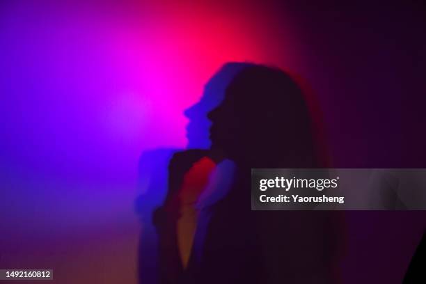 beautiful asian woman lit with neon lights - vorurteil stock-fotos und bilder