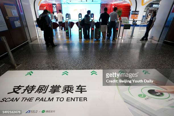 Poster promoting 'palm scanning service' is seen at a station on the Daxing Airport Express, a Beijing subway line, on May 21, 2023 in Beijing,...