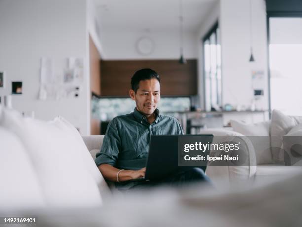 man working with laptop at home - usar portátil imagens e fotografias de stock