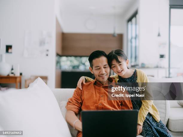 man working at home with his daughter - wireless technology family stock pictures, royalty-free photos & images