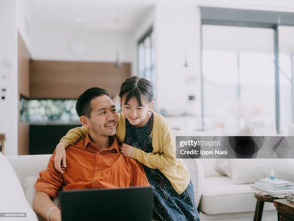 Man working at home with his daughter
