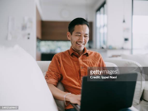 man working at home - asian man home laptop stock pictures, royalty-free photos & images