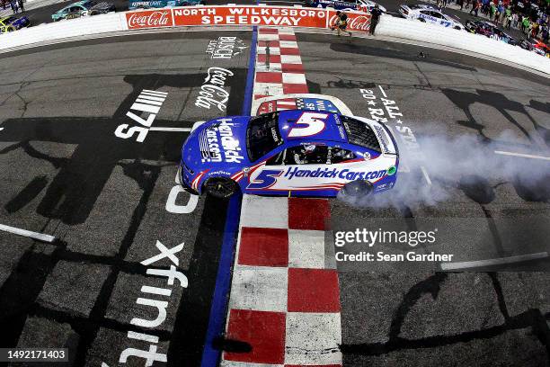 Kyle Larson, driver of the HendrickCars.com Chevrolet, celebrates with a burnout after winning the NASCAR Cup Series All-Star Race at North...