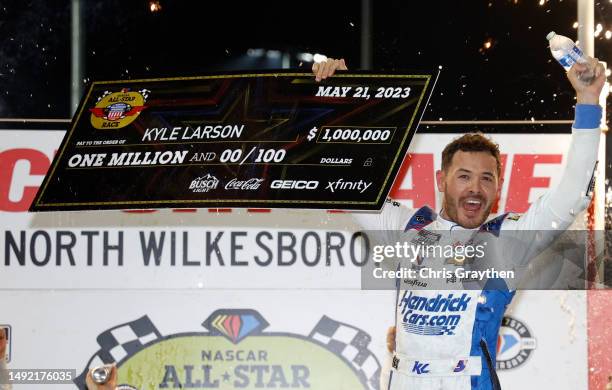 Kyle Larson, driver of the HendrickCars.com Chevrolet, celebrates with the one million dollar check in victory lane after winning the NASCAR Cup...