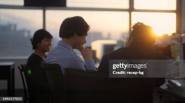 groupe d’hommes d’affaires multiethniques parlant avec désinvolture au bureau au coucher du soleil - femme dans un groupe dhommes photos et images de collection