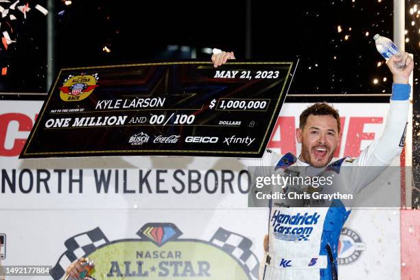 Kyle Larson, driver of the HendrickCars.com Chevrolet, celebrates with the one million dollar check in victory lane after winning the NASCAR Cup...