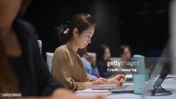 group of multi-ethnic business people working and having business meeting together in board room in office - multi ethnic business people having discussion at table in board room stockfoto's en -beelden