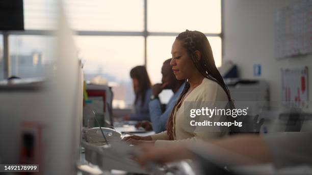 gruppe von geschäftsleuten, die bei sonnenuntergang im büro arbeiten - kundenbeziehungsmanagement stock-fotos und bilder