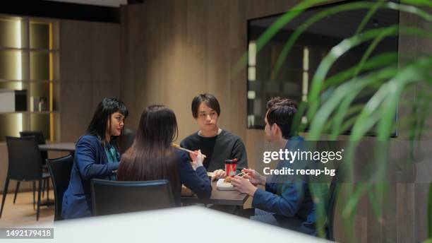 group of multi-racial business people having lunch together in office - workplace canteen lunch stock pictures, royalty-free photos & images