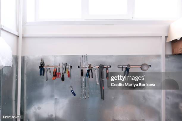 tools hang in a row on a magnetic strip. - magnetwand stock-fotos und bilder