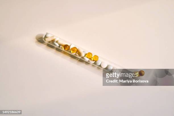 tablets, vitamins and dietary supplements in a test tube on a light background. - vitamins and minerals imagens e fotografias de stock
