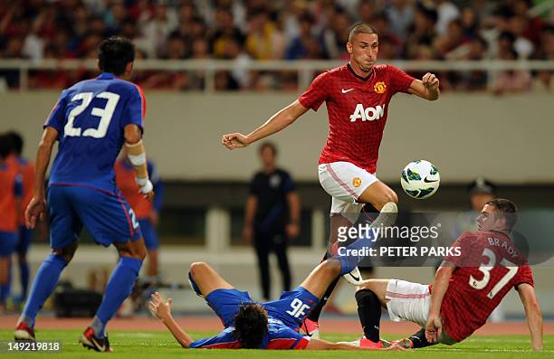 Frederico Macheda of Manchester United fights for the ball with Shouting Wang of Shanghai Shenhua as team mates Tianyi Qiu and Robbie Brady look on...