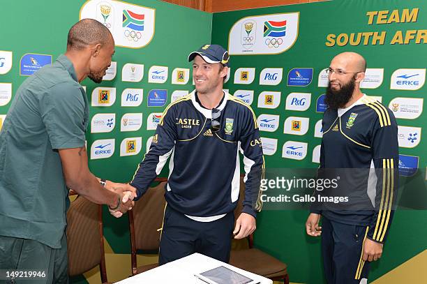 Long jumper Khotso Mokoena is greeted by AB De Villiers and Hashim Amla, Protea's cricketers, during the South African Olympic Team Press Conference...