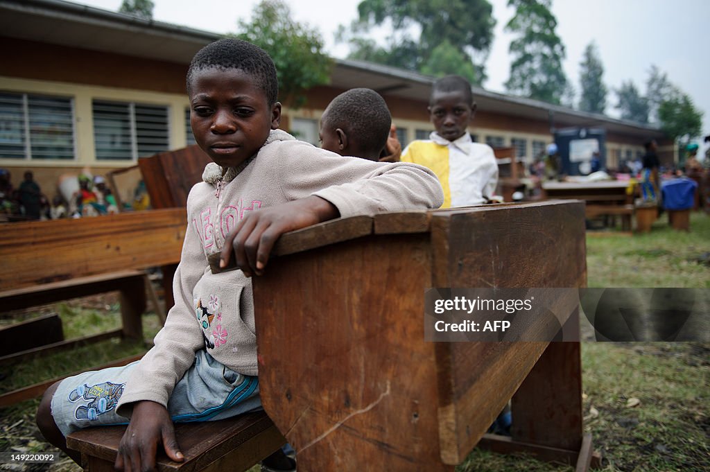 Displaced Congolese children sit on a sc