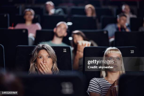 group of people watching a crime movie in cinema. - scary movie premiere stock pictures, royalty-free photos & images