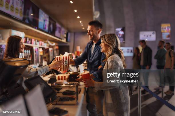 happy couple buying popcorn and drinks in cinema. - food vendor stock pictures, royalty-free photos & images