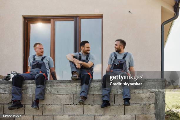 team von glücklichen arbeitern, die sich in einer pause auf der terrasse unterhalten. - resting stock-fotos und bilder