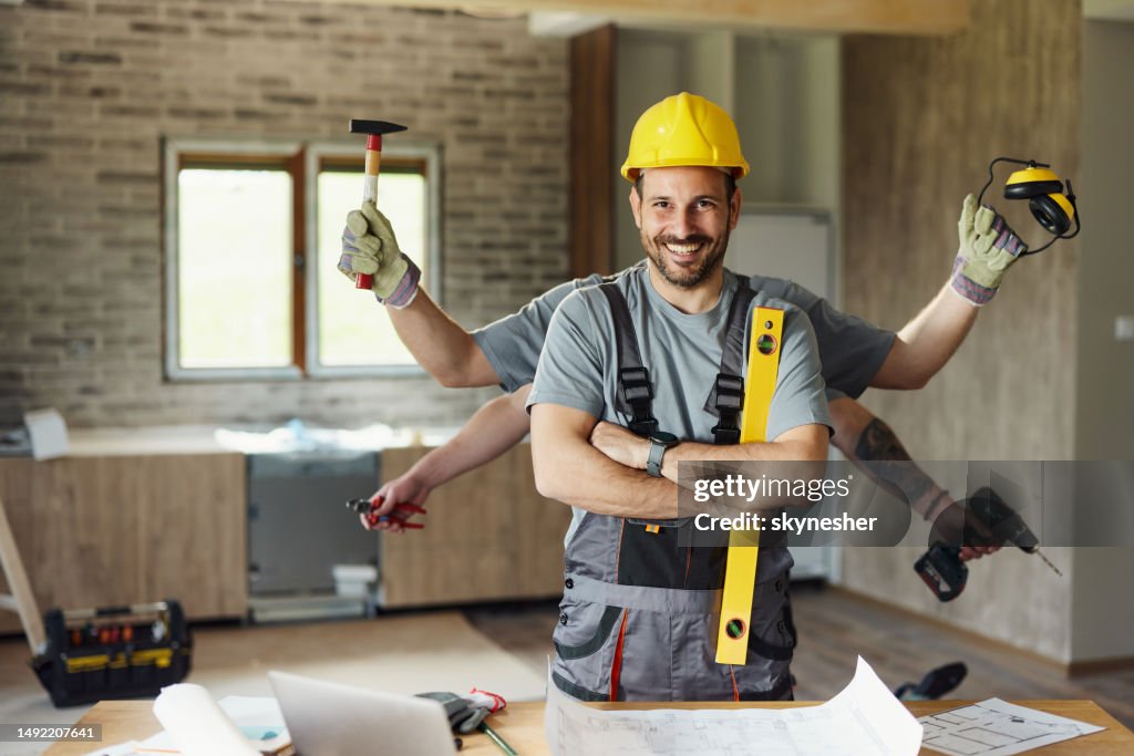 Glücklicher Multitasking-Bauarbeiter mit verschränkten Armen während des Renovierungsprozesses.