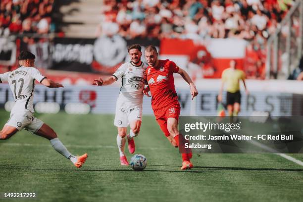 Jusuf Gazibegovic of SK Puntigamer Sturm Graz and Otar Kiteishvili of SK Puntigamer Sturm Graz challenges Strahina Pavlovic of FC Red Bull Salzburg...