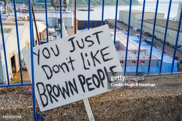 Banners are left by protestors above the dry dock where the Bibby Stockholm accommodation barge undergoes inspections and refurbishments on May 22,...