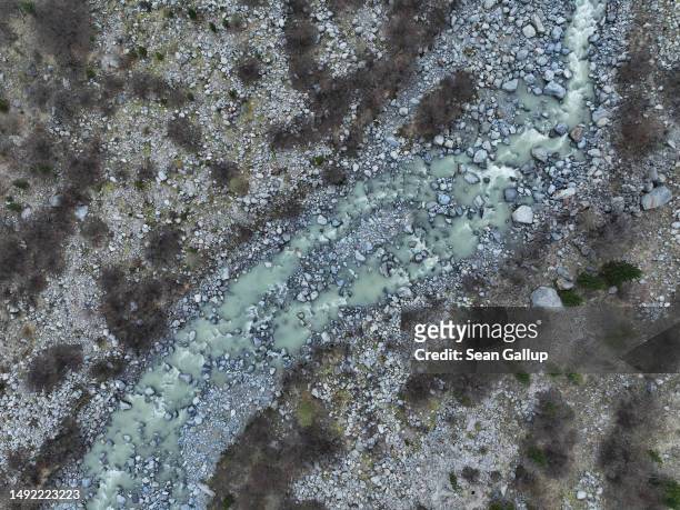 In this aerial view a river of meltwater runs through a basin at a spot the receding Morteratsch glacier filled completely in the 1920s on May 21,...