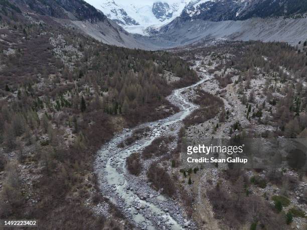 In this aerial view a river of meltwater runs through a basin at a spot the receding Morteratsch glacier, seen in the distance, filled completely in...