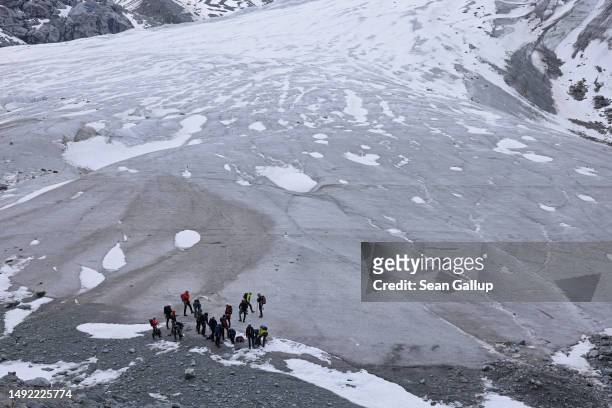 Alpinists prepare to walk across the receding Morteratsch glacier on May 21, 2023 near Pontresina, Switzerland. On June 18 Swiss voters will go to...