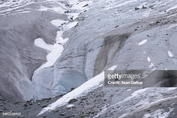 An alpinist walks near a collapsed portion of ice on the receding Morteratsch glacier on May 21, 2023 near Pontresina, Switzerland. On June 18 Swiss...
