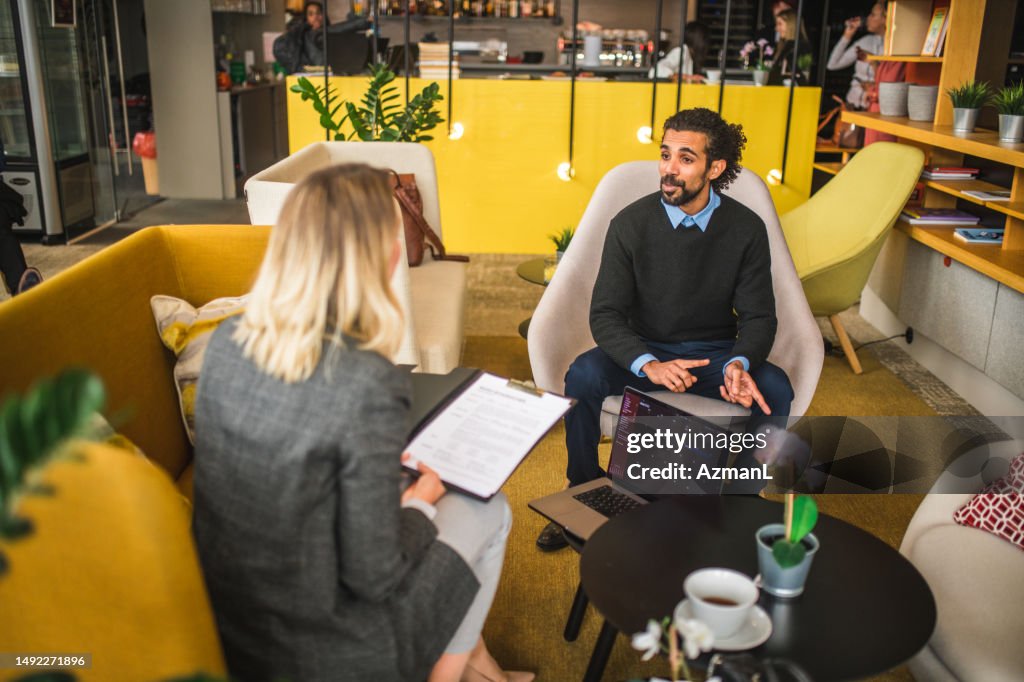 Middle Eastern Businessman Meeting Wiht A Caucasian Businesswoman In A Cafe